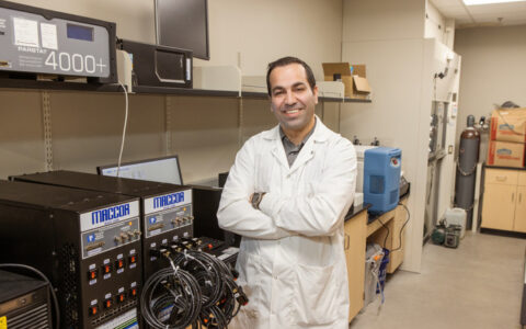 Researcher in lab coat in a U.S. Army-backed university lab with PARSTAT 4000+ equipment.