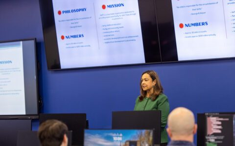 Woman presenting on philanthropy and community advancement, with presentation slides visible.