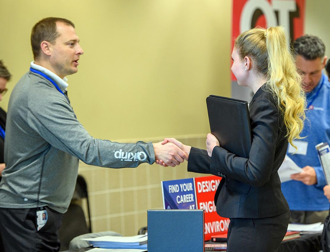 potential employer shaking hands with a female student