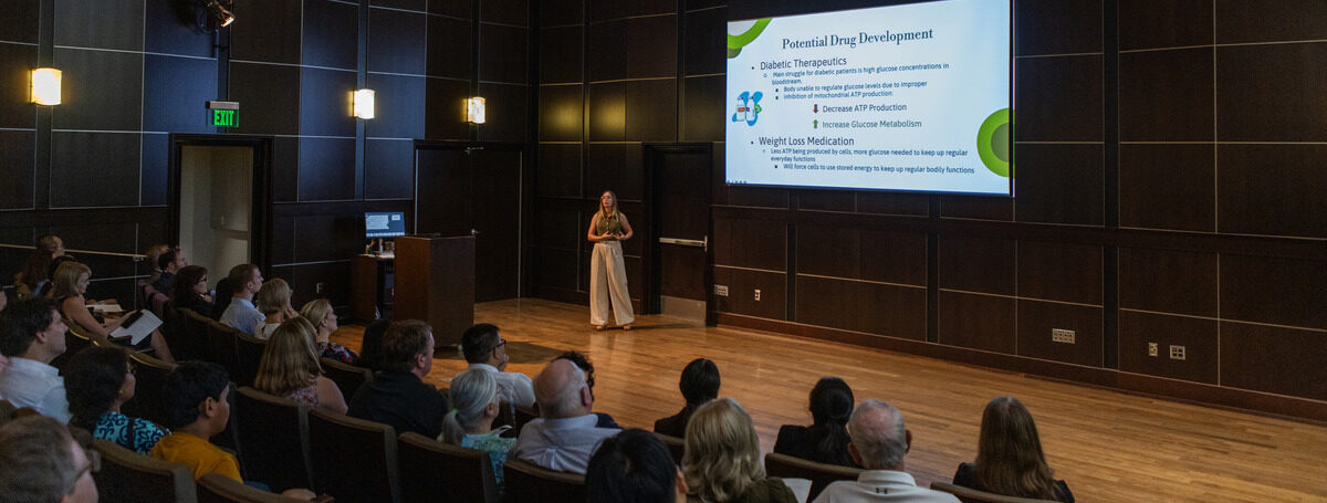 TU TURC student presenting research to an audience in an auditorium