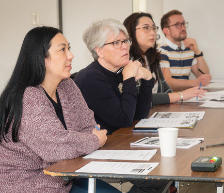 Photograph of colloquium panel participants listening to a presentation