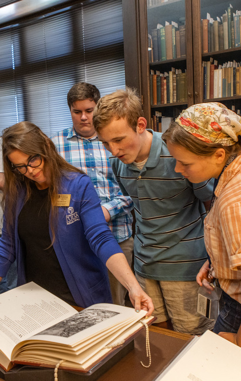 Students looking at a book in UTulsa's specials collections