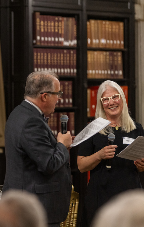 Two people speaking while holding scripts in McFarlin Library